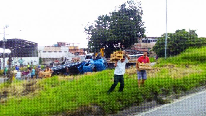 Roubo de cargas: pessoas saqueiam caminhão tombado no Laranjal, após acidente na RJ 104